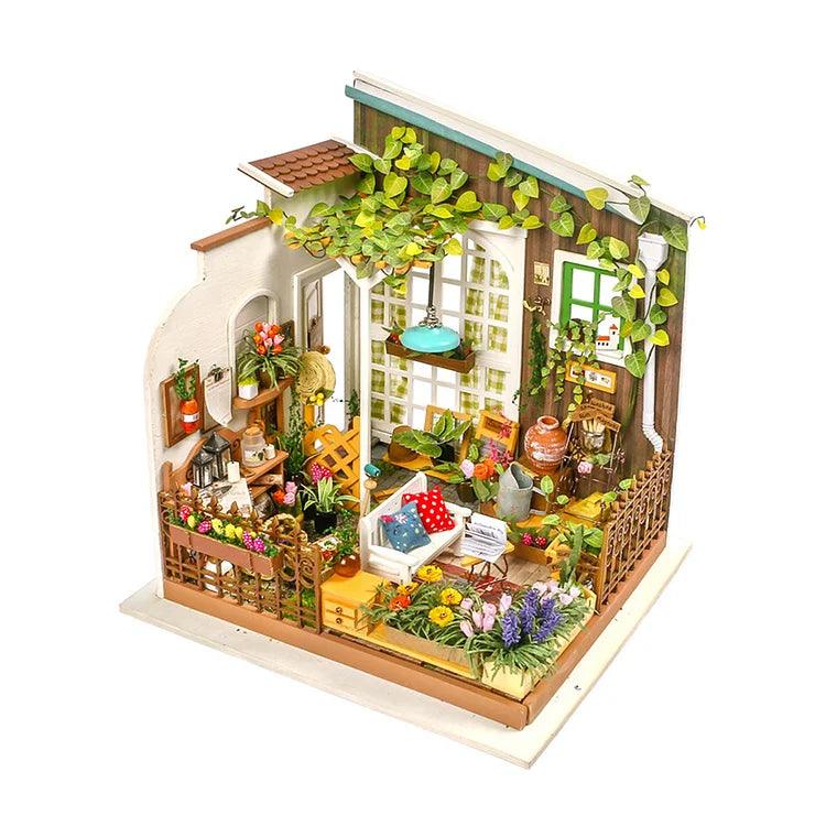 A detailed miniature diorama of an indoor garden scene, perfect for DIY green yard miniature house enthusiasts. It includes a small greenhouse with a variety of tiny plants, flowers, and gardening tools. Furniture includes a white bathtub filled with a pillow, shelves with jars, and a ladder with pots. The walls are adorned with climbing ivy—an ideal relaxing hobby and the best gift for flower lovers. Introducing Miller's Garden DIY Miniature House Kit by Rolife!