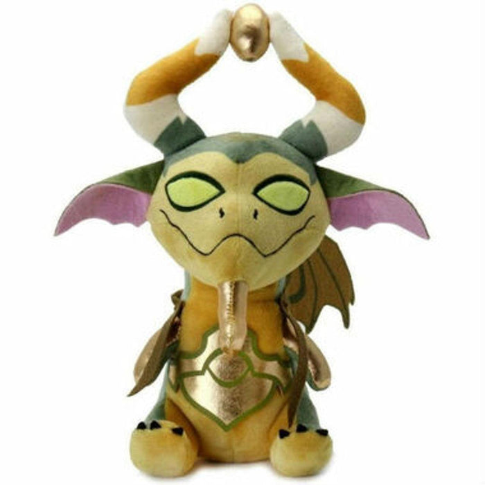 KidRobot's Magic: The Gathering - Phunny Plush - Nicol Bolas. The plush features green and yellow scales, pink wings, and curled horns holding a golden egg above its head. It has green eyes, gold accents on its chest and wings, with a cute and whimsical expression reminiscent of Nicol Bolas.