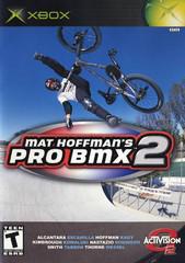 The Xbox cover for "Mat Hoffman's Pro BMX 2," by Activision, features a BMX rider performing a trick over a skatepark ramp. The game title is prominently displayed, rated "Teen" by the ESRB, and includes interactive environments. The Activision logo is visible at the bottom right.