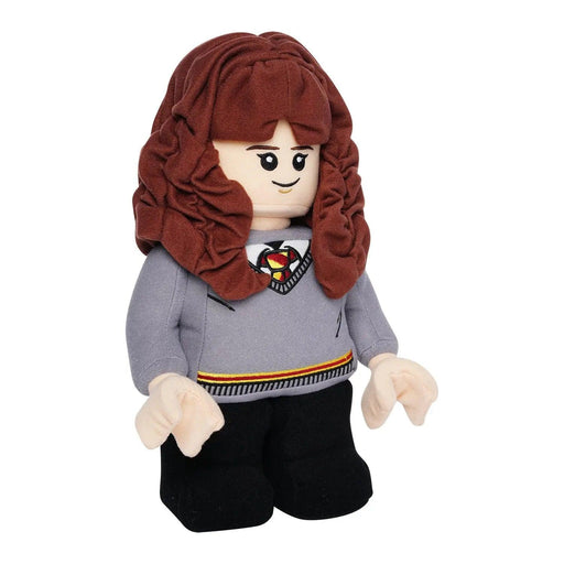 A Little Shop of Magic LEGO Harry Potter: Hermione Granger Plush Minifigure designed in the style of a LEGO minifigure, resembling LEGO Hermione Granger from Hogwarts. It has long brown curly hair, wears a grey sweater with a red, yellow, and black-striped tie like a school uniform, and black pants. The face features simple printed eyes and a smile.