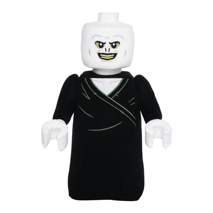 A LEGO mini-figure resembling a fictional dark wizard character from the Harry Potter books. The figure has a white, expressionless head with piercing eyes and a devious smile. Dressed in an all-black outfit with no visible legs, this ghostly figure echoes the eerie presence of Little Shop of Magic: LEGO Harry Potter: Lord Voldemort Plush Minifigure.