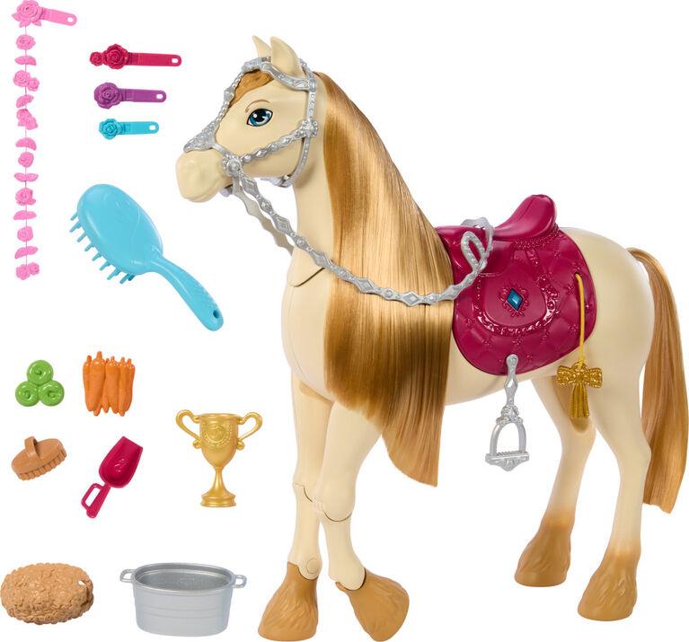 A Barbie Mysteries: The Great Horse Chase Interactive Toy Horse by Mattel with a long golden mane and tail, wearing a pink saddle and silver bridle. Accessories around it include a blue brush, various hair clips, ribbons, carrots, a trophy, a food bowl, a water bucket, and a saddle blanket. The horse’s tack is detailed with heart and jewel designs.