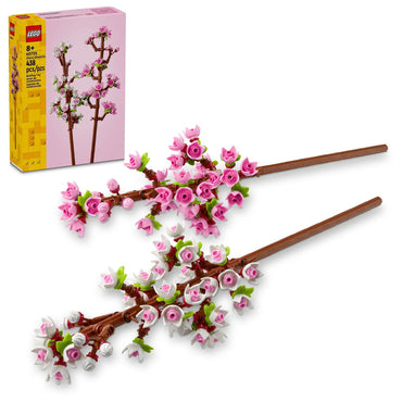 Image of the LEGO Cherry Blossoms Celebration Gift set from Lego, perfect for adding some spring colors to your room decor. The set features two brown branches adorned with numerous pink and white blossoms, leaves, and small flower clusters. The packaging is visible in the background, showcasing the assembly details.