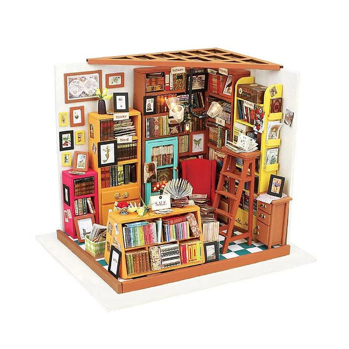 A detailed miniature model of a cozy bookstore, reminiscent of the Rolife DIY Miniature Dollhouse- Sam's Study by Rolife, filled with colorful bookshelves packed with books, a wooden ladder, framed pictures on the walls, and several small knick-knacks. The ceiling includes a skylight, and the floor has a green and white checkered pattern—a perfect DIY miniature house kit for enthusiasts.