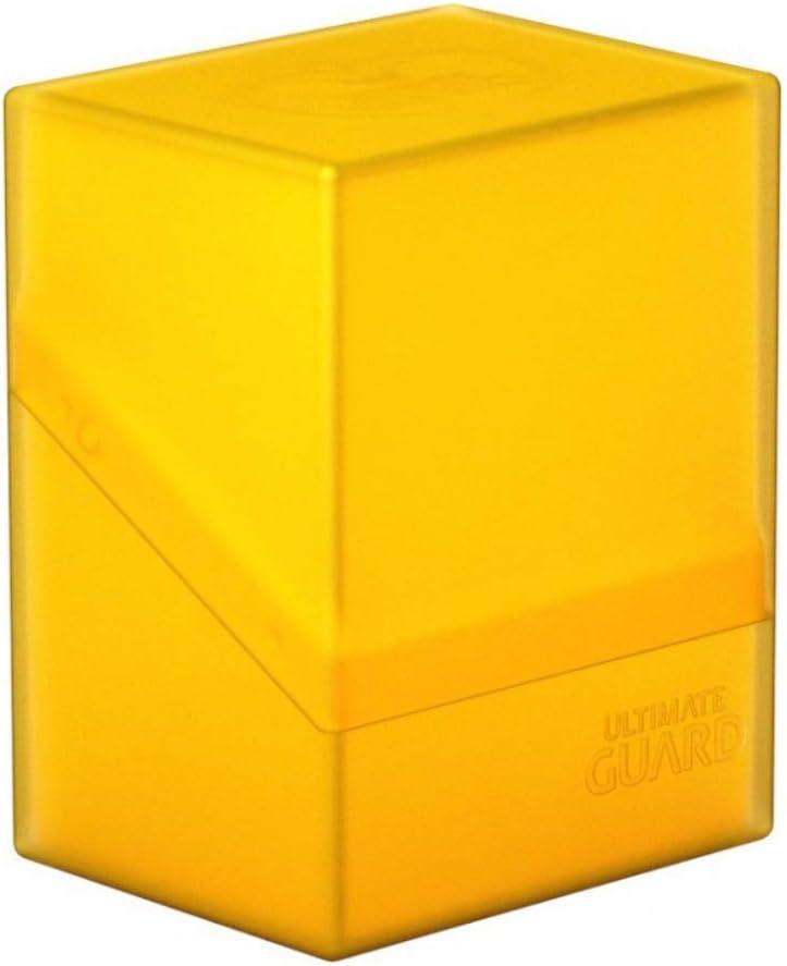 The Ultimate Guard Boulder 80+ Deck Case Amber is a transparent yellow cubic container with a slightly slanted lid. The durable box features a smooth surface embossed with the text 