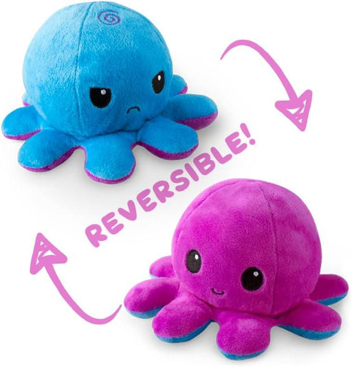 A cute TeeTurtle Reversible Blue and Purple Octopus Plushie showcasing its two different sides. The blue side has an angry expression with furrowed eyebrows, while the purple side has a happy face with big, cheerful eyes. "REVERSIBLE!" text is in the center, with arrows pointing to each side of this super soft toy from Everything Games.