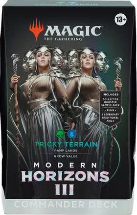 Box of Magic: The Gathering Modern Horizons 3 Commander Deck titled "Tricky Terrain". The artwork shows two female figures in elaborate armor holding staffs, surrounded by spectral faces. Tagline: "Grow Value". Aged 13+. Includes collector booster sample pack, plus 2 legendary traditional foils.