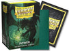 The image shows a box of Arcane Tinmen Dragon Shield: Standard 100ct Sleeves - Power (Dual Matte) labeled "Power," specifically 100 matte dual sleeves. The box features artwork of a green dragon surrounded by mist. In front of the box are a single green trading card sleeve and the back of a sleeved card.