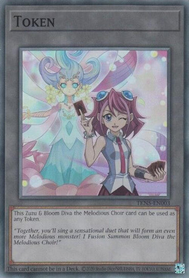 A Yu-Gi-Oh! trading card titled "Token: Zuzu and Bloom Diva the Melodious Choir [TKN5-EN003] Super Rare" features an illustrated girl with pink hair, wearing a blue dress and holding a card, winking and smiling. Behind her is a ghostly, serene figure with flowing blue and purple hair. This Super Rare card text mentions summoning the "Melodious Choir.