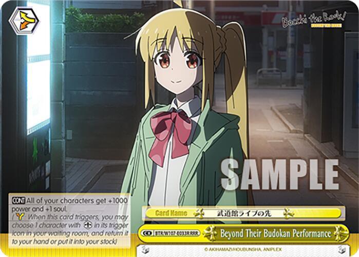 A colorful anime-style trading card featuring a blonde female character in a school uniform with a large pink bow. She stands in an urban setting with various buildings and a dimly-lit background. The card, possibly from "BOCCHI THE ROCK!", has text and logos at the bottom, along with the title "Beyond Their Budokan Performance (BTR/W107-E033R RRR) [BOCCHI THE ROCK!]" by Bushiroad.