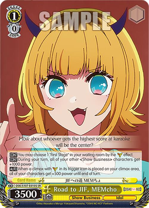 Image of a trading card featuring "Road to JIF, MEMcho (OSK/S107-E010S SR)," a Super Rare character from [OSHI NO KO] by Bushiroad. The character has blonde hair, blue eyes, and small red horns on her head. She is depicted with an open mouth and a joyful expression. The card displays various statistics and game text, framed by a yellow and brown border design.