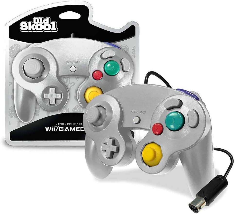 The Old Skool Silver Gamecube/Wii Controller has dual analog sticks, a D-pad, colorful A/B/X/Y buttons, L/R shoulder buttons, a Z button, and pressure-sensitive controls. It includes a visible cord with an end connector and is packaged with matching branded packaging in the background.