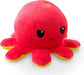 A plush toy resembling an octopus with a bright red body and eight tentacles. The Everything Games TeeTurtle Reversible Red and Yellow Octopus Plushie has a small frown and large black eyes with a yellow outline. The bottom of the tentacles is yellow, contrasting with the red top and main body. There is a spiral mark on the top of its head.