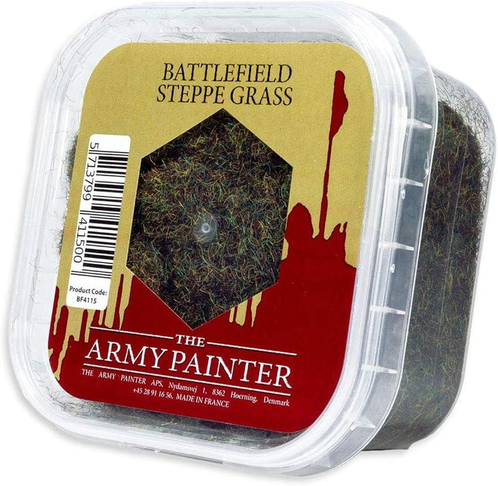 A close-up image of a plastic container of Army Painter's The Army Painter Battlefield: Steppe Grass Basing, ideal for creating realistic models. The see-through container has a red label with a clear window showing green artificial grass inside. The label includes a barcode, product code BF4115, and mentions it's made in France. Plus, it's easy-to-store!