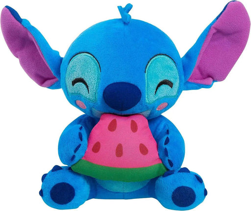 A Disney Stitch Feed Me Small Plush from Disney featuring a blue alien-like character with large purple inner ears and a small tuft of blue hair. Stitch is smiling with closed eyes and holding a slice of pink watermelon with black seeds and a green rind. This beanbag plush has a playful and adorable appearance.