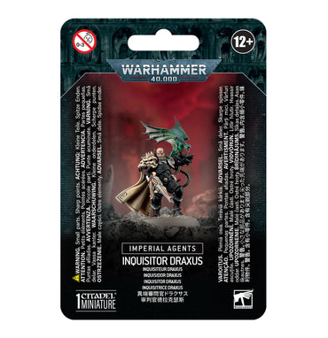 The image shows a blister pack for the Games Workshop miniature "Imperial Agents: Inquisitor Draxus" from Warhammer 40,000. It features the painted figure with detailed armor and a futuristic weapon, plus multilingual age restrictions and safety warnings.