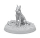 A white figurine of a seated German Shepherd on a round base, perfect for any Fallout: Miniatures - Hollywood Heroes (Amazon TV Show Tie-In) set by Modiphius. The dog holds a human hand in its mouth, and the base is textured with detailed ground features including bones, rocks, and vegetation. The entire sculpture is monochromatic and intricately designed.