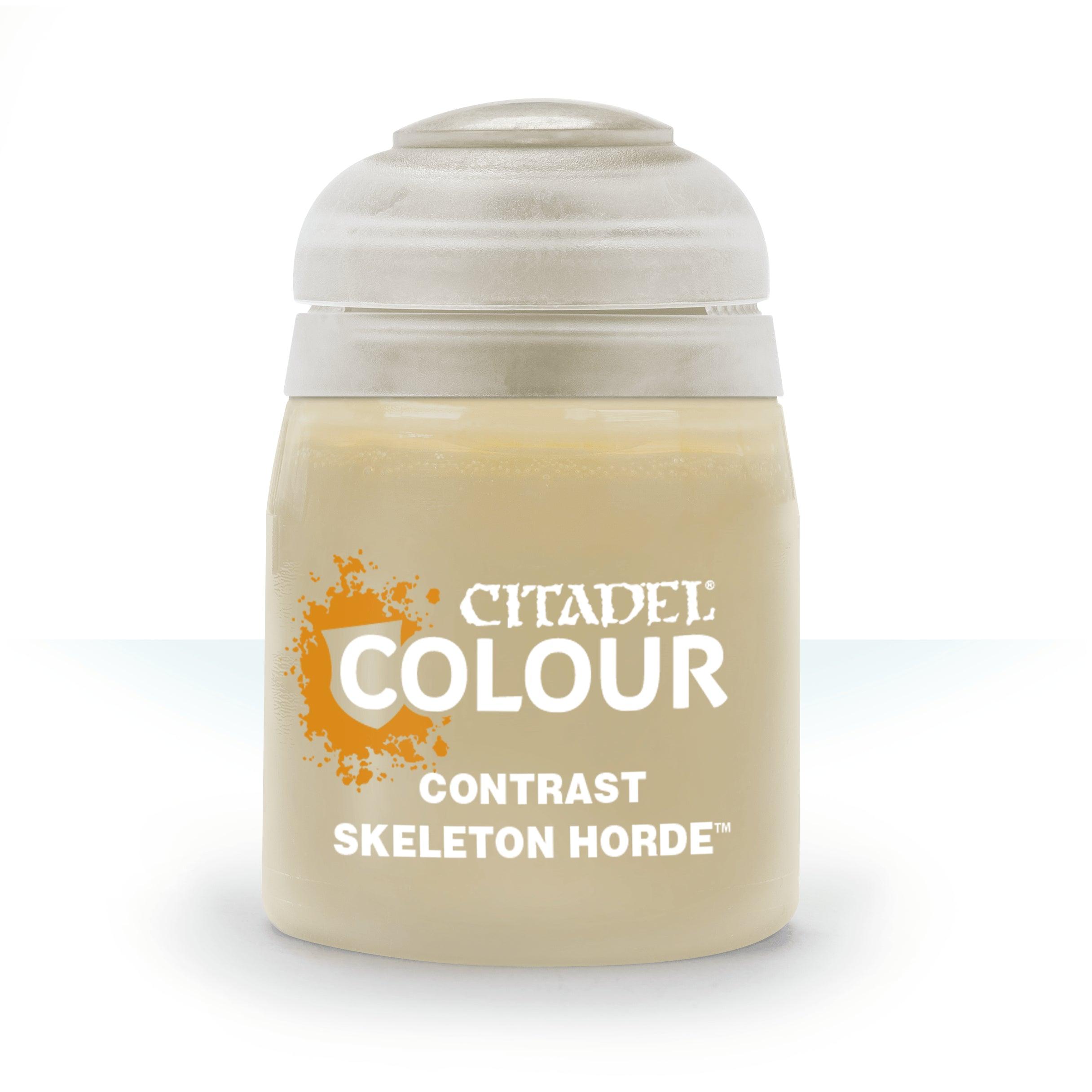 A cylindrical jar of Citadel Contrast - Skeleton Horde paint promises realistic shading. It features a gray flip-top lid, and the label showcases orange paint splatter graphics against a gradient from blue to white.