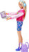 A blonde doll with long hair stands holding a laptop. She wears a pink and white jacket with colorful designs, plaid shorts, and blue sneakers. Light blue headphones rest on her head. A purple backpack is placed on the ground next to her. This Mattel Barbie-I Love School-Blonde Doll captures the excitement of back to school perfectly.