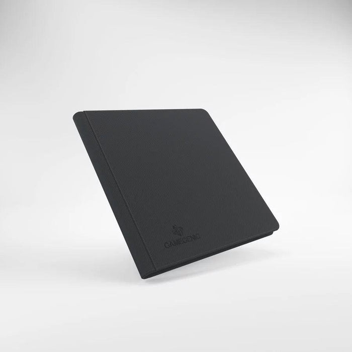 A sleek, closed black ZIP-UP ALBUM 24-POCKET - BLACK stands upright against a gradient white background. The album, crafted with a Nexofyber surface, has a textured cover and features the logo and name "Game Genic" subtly embossed in the bottom center of the front cover. The overall design is minimalist and professional.