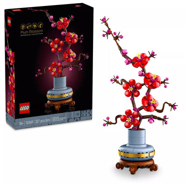 The LEGO Icons Plum Blossom Flower Décor Display Set 10369 from the LEGO Botanical Collection features a vibrant plum blossom tree with pink and red flowers on brown branches in a grey and yellow pot, displayed on a wooden stand. The black box highlights the assembled tree and LEGO branding.