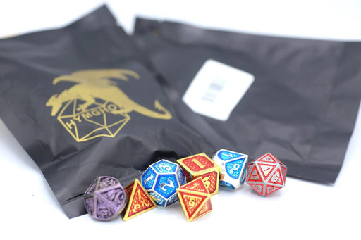 A collection of colorful polyhedral dice, including d20, d12, d10, d8, d6, and d4, are displayed in front of two dark gray bags. The bags feature a gold dragon logo and text that says "HYMGHO." The dice have vibrant designs in red, blue, purple, and yellow hues with intricate patterns. This full set of Mystery Pack Full set Non-matching Solid Metal Dice is perfect for any tabletop gaming enthusiast.