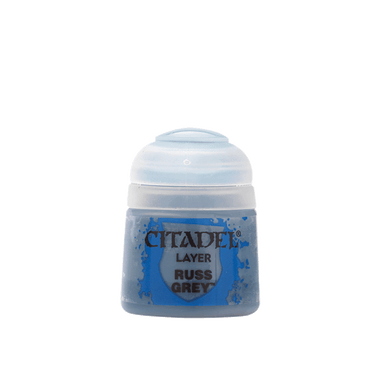 The Citadel Layer - Russ Grey by Citadel is a small, clear plastic paint pot with a rounded lid and blue label. Containing blue-grey paint, it's perfect for edge highlighting miniatures. Blue paint splatters embellish the text against a solid grey background.