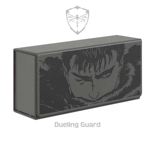 A rectangular card deck box fashioned from vegan leather and adorned with a dark, illustrated design of a serious-looking character with furrowed brows and intense eyes. Above the box is a subtle logo of a shield with crossed swords, and below it is the text "The Struggler Deck Box by Dueling Guard.