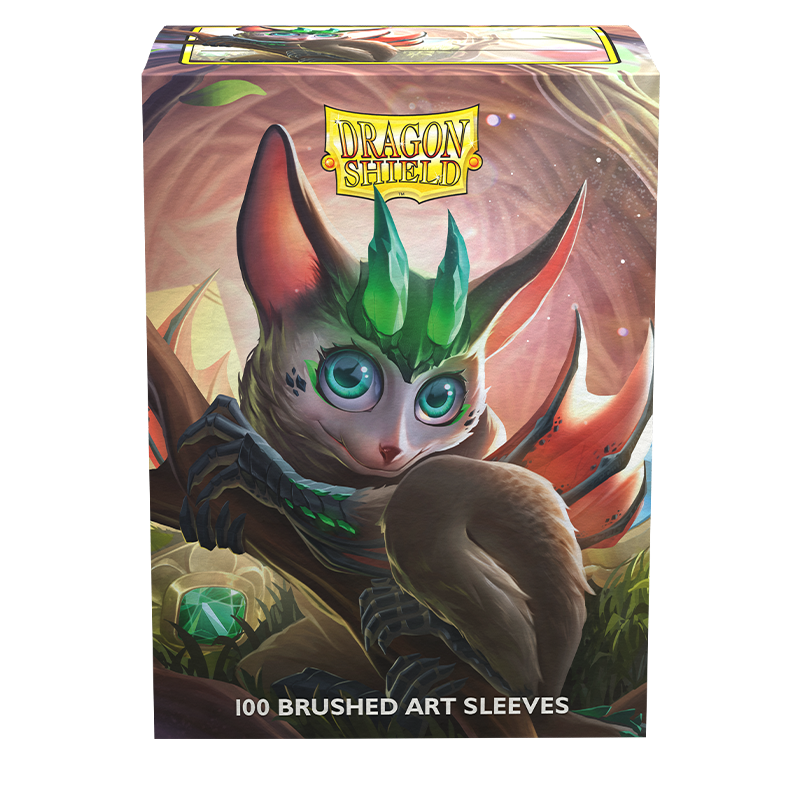 An artwork featuring a fantasy creature with large ears, vivid green eyes, and a leaf-shaped crest, sitting on a branch. Its brown fur and gentle expression create an enchanting presence as it overlooks a magical forest. The scene is crowned with "Dragon Shield" while "100 Brushed Art Sleeves" ensures protection for your TCG cards below. This product is known as Dragon Shield: Standard 100ct Brushed Art Sleeves - The Bushdrake by Arcane Tinmen.