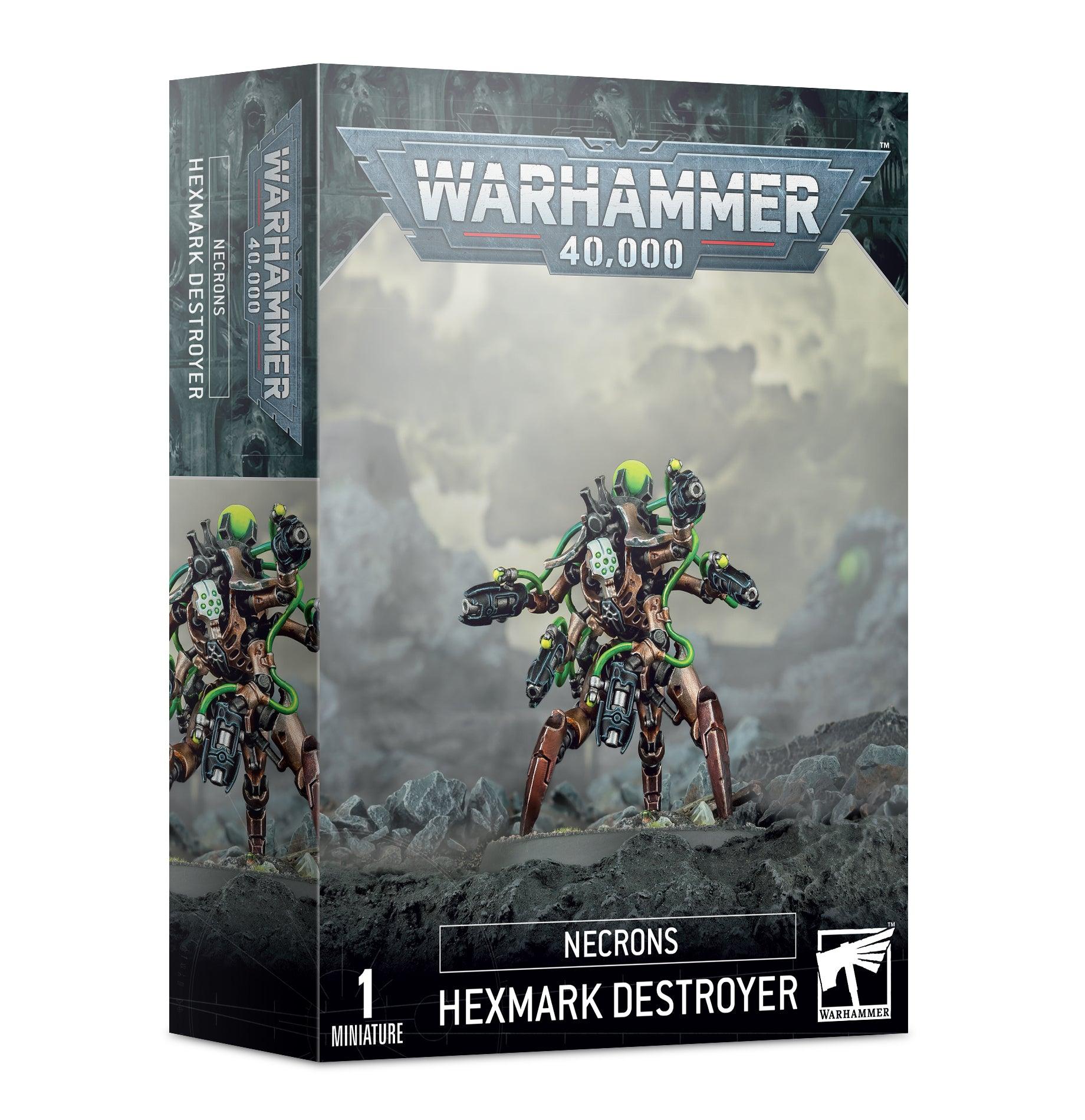 The image shows the packaging for a Games Workshop figure, specifically the NECRONS: HEXMARK DESTROYER. The box features a detailed illustration of the hex-legged, cybernetic figure wielding enmitic disintegrator pistols, set against a smoky, war-torn backdrop. The text on the front includes 