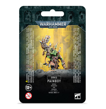 The image displays the packaging for a Games Workshop ORKS: PAINBOY model kit. Featured on the front is artwork of a green Ork with Dok’s tools. Text includes product details and safety warnings over gothic architecture. Intended for ages 12+.