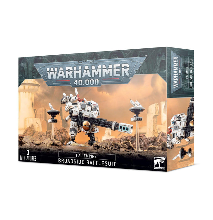 The image shows a box of the Games Workshop T'AU EMPIRE: BROADSIDE BATTLESUIT model kit. The box is predominantly blue and gray, with the Warhammer 40,000 logo at the top. It includes an image of a Broadside Battlesuit model armed with a heavy rail rifle and states that it contains three miniatures.