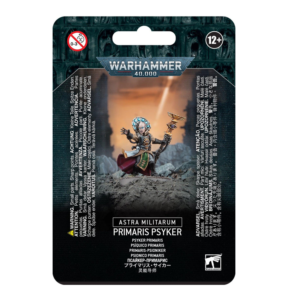 The image shows a Games Workshop package labeled "Astra Militarum: Psyker," featuring a detailed Warhammer 40,000 miniature in dynamic pose on a battlefield. The packaging includes an age restriction of 12+ and multilingual warnings.