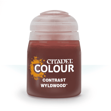 Image of a small cylindrical container of Citadel paint with a transparent lid. The label displays the brand name "CITADEL" in white text with a yellow paint splatter design and the words "Citadel Contrast - Wyldwood" in gray below it. The paint color, perfect for realistic shading, appears to be a rich brown shade.