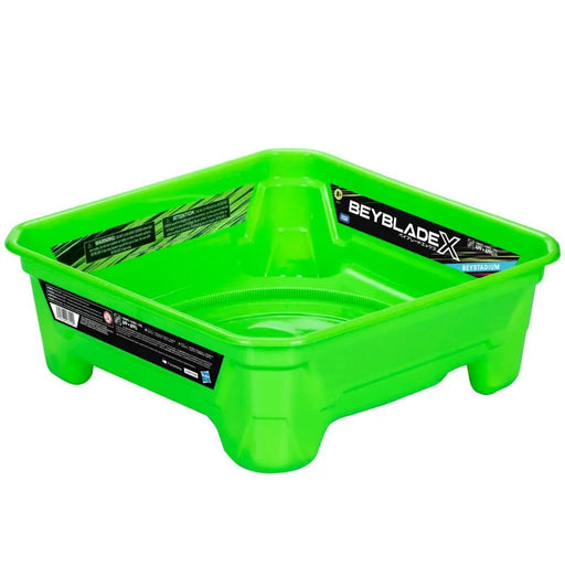 The Beyblade X Beystadium Battle Arena for Spinning Top-Toys by Hasbro is a vivid green rectangular arena with elevated sides. The inner walls bear the "Beyblade X" branding along with promotional text and graphics in black and white. It features an Accelerator Gear System, with a ribbed circular design at the base to ensure intense Beyblade battles.