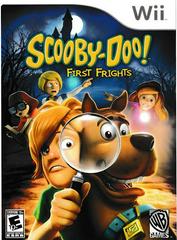 The image is the cover for WB Games' "Scooby-Doo First Frights" on Nintendo Wii. It shows Scooby-Doo with a magnifying glass and Shaggy, while Velma, Fred, and Daphne can be seen in the background. A spooky mansion and full moon enhance the mystery-themed atmosphere.