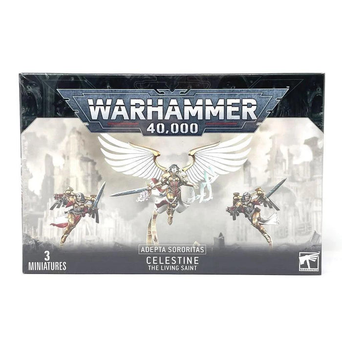 Box cover of Games Workshop's ADEPTA SORORITAS: CELESTINE LIVING SAINT set featuring "Celestine the Living Saint" from the Adepta Sororitas faction. The image shows Celestine centrally positioned with large white wings outstretched, flanked by Geminae Superia. The backdrop depicts a war-torn cityscape.