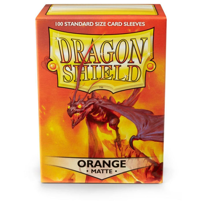 The image shows a box of Arcane Tinmen brand card sleeves. The box is orange with fiery artwork featuring a menacing black dragon breathing fire. The text on the box reads "100 Standard Size Card Sleeves," "Dragon Shield: Standard 100ct Sleeves - Orange (Matte)," and "Orange Matte" at the bottom, highlighting its premium matte sleeves.