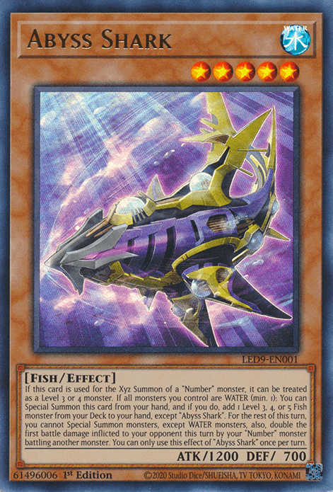 Image of a Yu-Gi-Oh! trading card named "Abyss Shark [LED9-EN001] Ultra Rare." The card depicts a large, armored fish-like creature with sharp fins and glowing eyes swimming in a dark ocean. It's a Level 5 Water-type monster with 1200 ATK and 700 DEF, belonging to the "Fish/Effect" category.