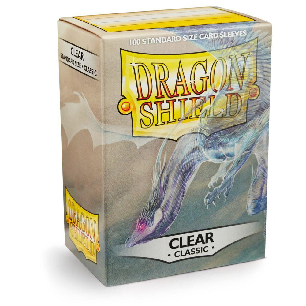 A box of Arcane Tinmen's Dragon Shield: Standard 100ct Sleeves - Clear (Classic) offers card protection with a glossy back and features a dragon illustration on the front. It contains 100 standard-size sleeves, showcasing a color scheme that blends soft blue, gray, and yellow tones, accented by a dragon's wing gracefully extending across the front.