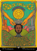 A colorful fantasy card features a central figure with closed eyes and a gentle expression, being crowned by two hands from above. Text reads "Dawn of a New Age (Borderless Poster) [The Lord of the Rings: Tales of Middle-Earth]" with rules for gameplay. The background features mystical symbols, green mountains, and a golden sun, invoking mythical enchantment. This is part of the Magic: The Gathering brand.