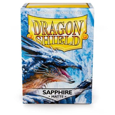 A box of Arcane Tinmen Dragon Shield: Standard 100ct Sleeves - Sapphire (Matte) with an illustration of a blue dragon. The dragon roars amidst an icy, snow-covered terrain, perfectly matching the set's frosty theme. Containing 100 standard-size matte sleeves, the box features a striking blue and white background.