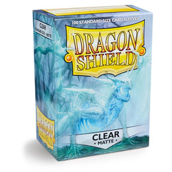 Box of Dragon Shield: Standard 100ct Sleeves - Clear (Matte). The durable box displays the brand name Arcane Tinmen in large yellow letters on a shield-shaped logo, with an image of a dragon in a misty, blue background. The text indicates that the box contains 100 clear matte card sleeves.