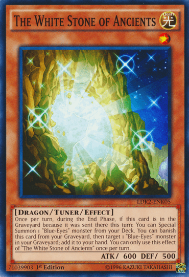 A Yu-Gi-Oh! card named "The White Stone of Ancients [LDK2-ENK05] Common" features a glowing white and blue crystal embedded in jagged rocks, with rays of light shining outward. This Dragon/Tuner/Effect Monster with 600 ATK and 500 DEF allows the special summoning of Blue-Eyes monsters.