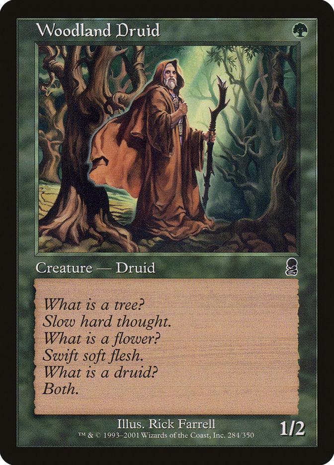 The Magic: The Gathering card "Woodland Druid" from the Odyssey collection depicts a druid in a brown cloak wielding a staff, surrounded by ancient trees. It includes text that reflects on the relationship between druids and nature. This creature card has power and toughness stats of 1/2.