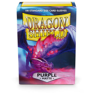 Image of an Arcane Tinmen Dragon Shield: Standard 100ct Sleeves - Purple (Matte) box. The box displays a purple dragon with wings spread against a fiery backdrop. The top reads "100 Standard Size Card Sleeves" in white text on a blue background. Large "Dragon Shield" text in gold is centered. Below, text reads "PURPLE MATTE durable card sleeves" in black on white.