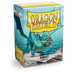 The Arcane Tinmen Dragon Shield: Standard 100ct Sleeves - Mint (Matte) box features a green dragon with wings outstretched over a rocky landscape against a blue-gray sky, encapsulating the magic of these premium matte sleeves.