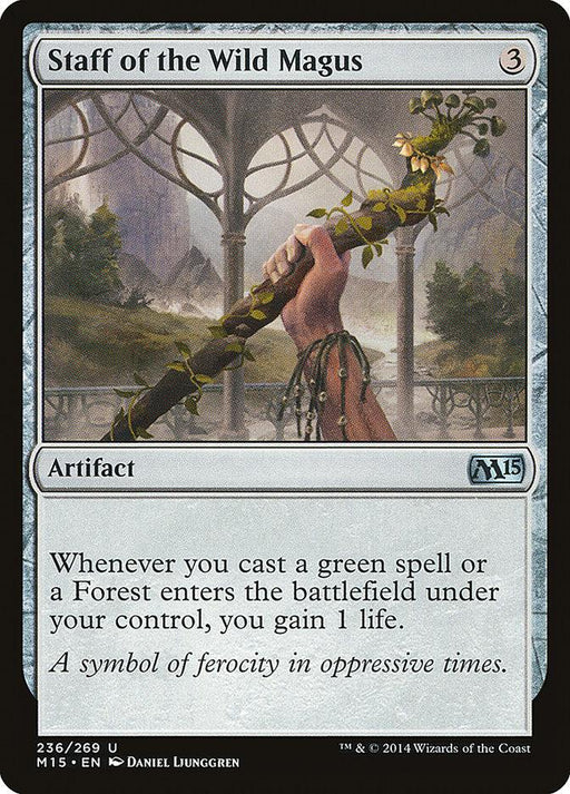A Magic: The Gathering card titled "Staff of the Wild Magus [Magic 2015]" from Magic: The Gathering. It shows a hand gripping a staff entwined with vines and tendrils. The card's border is black, and the background depicts an arched stone structure with mountains. Text below describes its artifact abilities and flavor text.