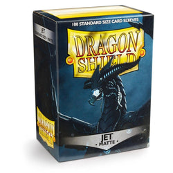 A box of Arcane Tinmen's Dragon Shield: Standard 100ct Sleeves - Jet (Matte) features a menacing black dragon. The box is labeled "Dragon Shield" in large yellow and red letters, and below it reads "Jet - Matte," indicating the sleeve color and texture. These durable card sleeves come in a pack of 100 standard size sleeves.