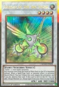 An image of a Yu-Gi-Oh! Gold Rare card titled "Herald of the Arc Light [MAGO-EN028] Gold Rare." It features a winged, mechanical being with a colorful, glowing aura. The card has a white frame, is a Synchro/Effect Monster Fairy type with Light attributes. It has 600 ATK and 1000 DEF points and can negate activation.